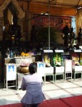 A woman in prayer outside The Golden Buddha.